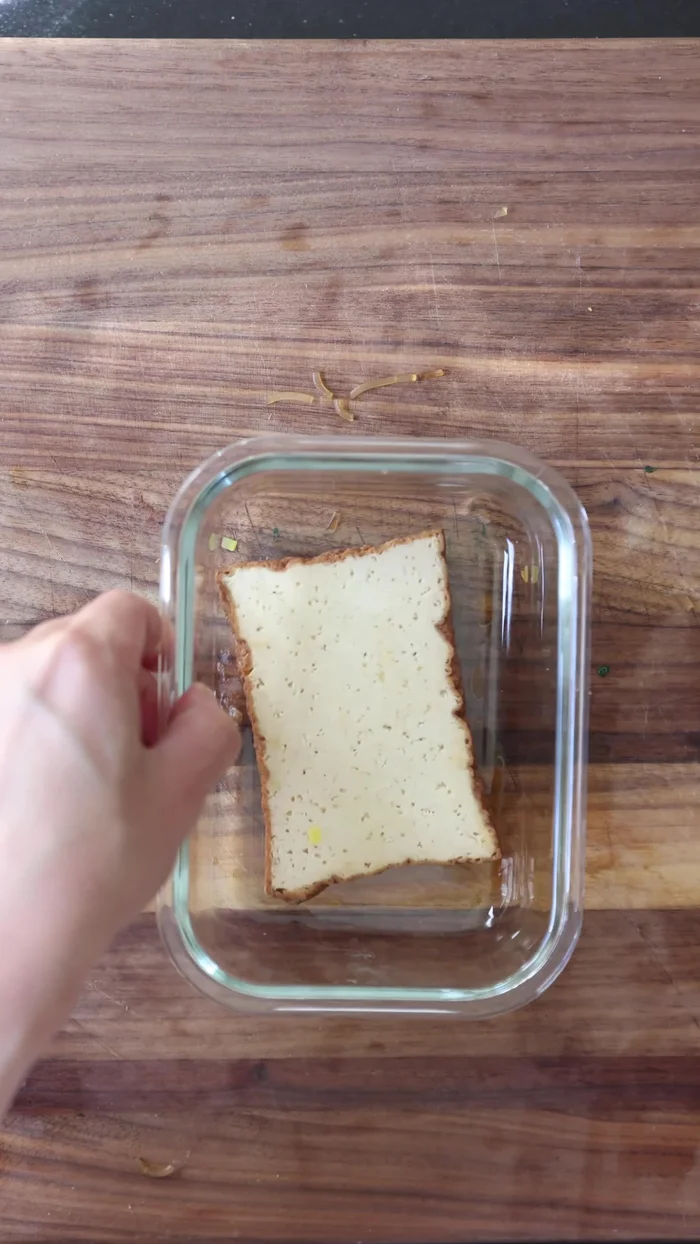 Assemble Spiral Kimbap: Paste two (or 1.5) seaweed sheets together for extra length. Spread rice over the long sheet, then top with a standard-sized sheet. Layer fillings in the same order as shown in the screenshot (see video).