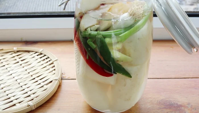 Add the chili paste to the container with the radishes.