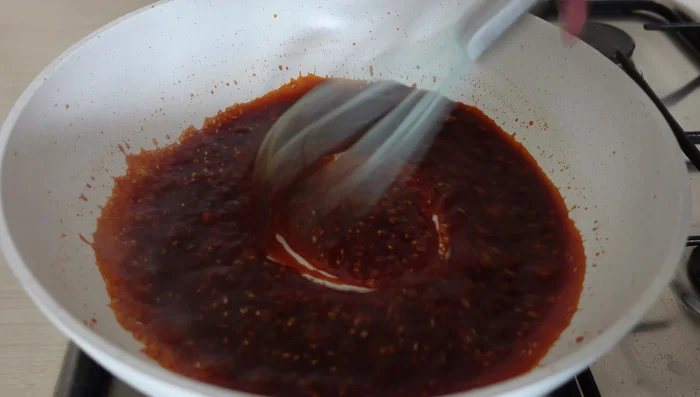 Simmer the sauce until thickened, then stir in sesame seeds and sesame oil (152.519).