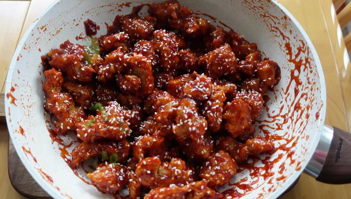 Garnish the cooked chicken with sesame seeds and spring onions (177.12).