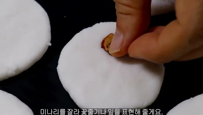 Place a piece of jujube on the center of each pancake, then decorate with water parsley leaves.