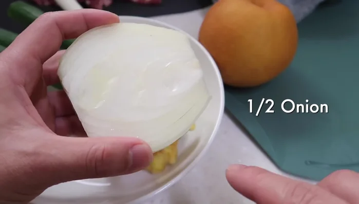 Blend aromatics: Blend onion, Korean pear (or western pear), ginger, and spring onions.