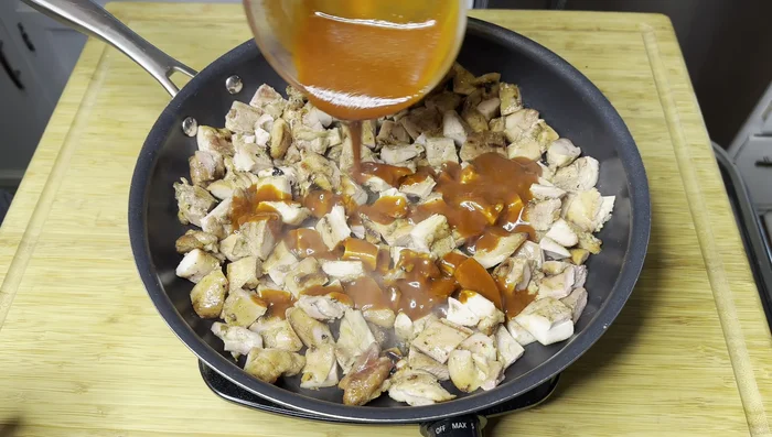 Finish the dish: Heat a pan over medium-high heat. Add the cubed chicken and pour the sweet and spicy sauce over it. Toss to coat and let it simmer for a short time until the sauce caramelizes.