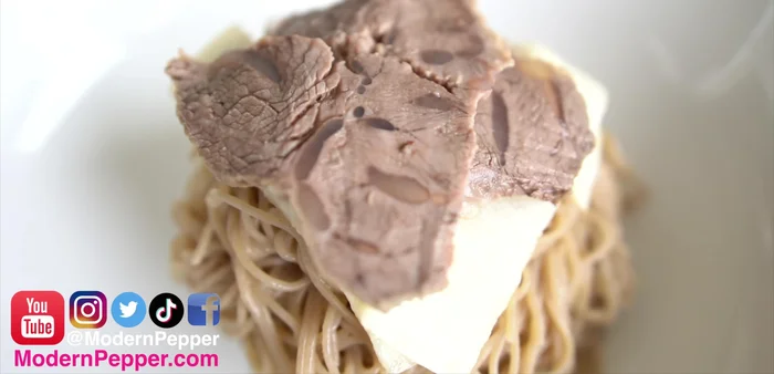 Assemble the Mul Naengmyeon: Layer noodles in a bowl, top with pickled radish and cucumber, cold beef slices (optional), Korean pear (optional), hard-boiled egg (optional), sesame seeds (optional), and kimchi (optional). Pour the chilled broth over the noodles, and mix.