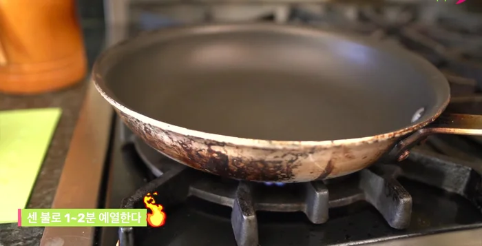 Heat a frying pan over high heat. Add a little less than a tablespoon of oil.