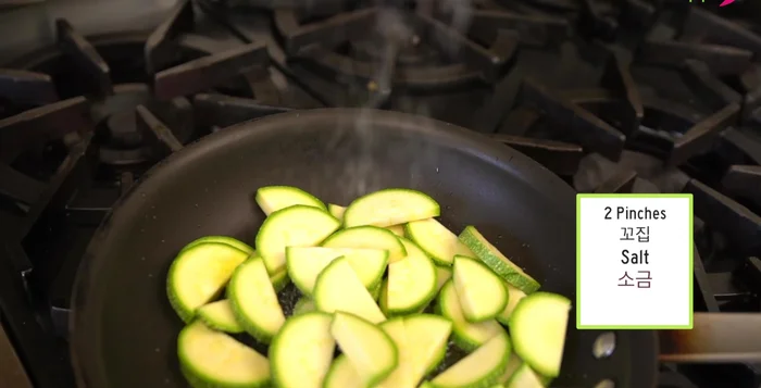 Add the squash to the hot pan. Add salt, black pepper, and stir-fry for 1 minute. Add the onions, another pinch of salt, and stir-fry for 30 seconds.