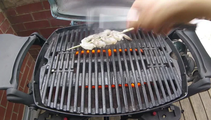 Place shrimp skewers on the grill grate, pressing down to ensure contact. [213.28]