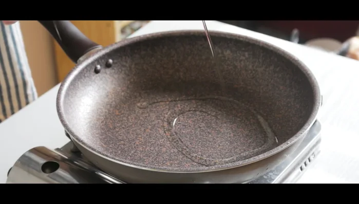 In a larger skillet, sauté the prepared vegetables with sesame oil.