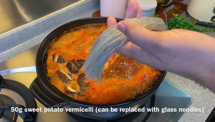 Once boiling, add sweet potato vermicelli and spring onions. Boil for 3 minutes.