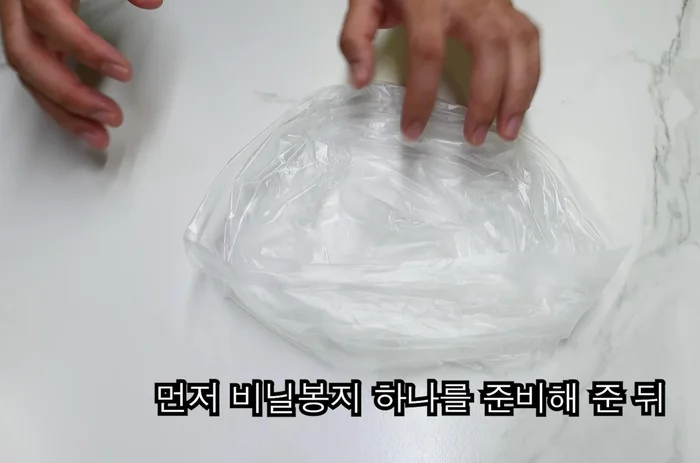 Prepare a plastic bag. Add 100-150g of thinly sliced pork belly, salt, and pepper.