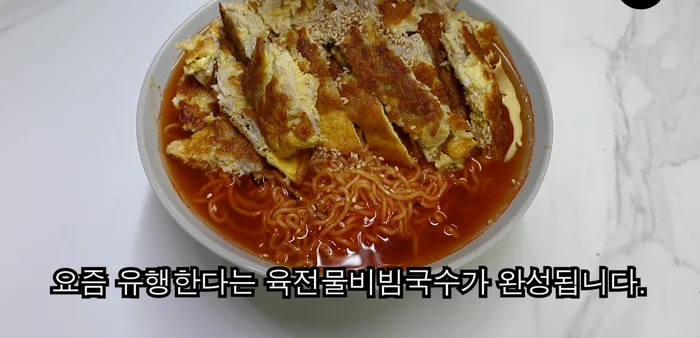Place the meat jeon generously on top of the bibim noodles and serve.