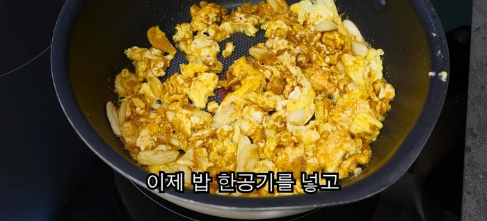 Add a bowl of rice and a spoonful of ketchup. Fry the rice evenly.