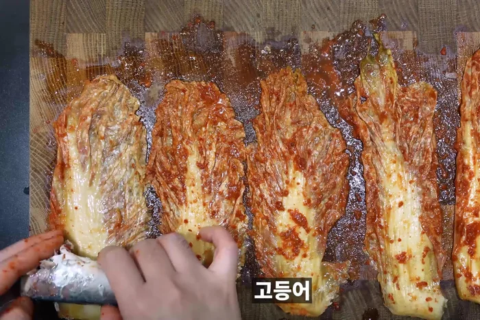While the stew simmers, wrap mackerel in kimchi.