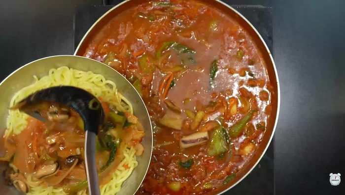Pour a generous amount of Jjamppong broth over the boiled Chinese noodles.