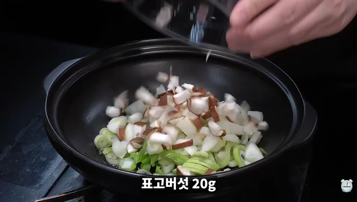 Add cooking oil, green onion, onion, shiitake mushrooms, and red pepper powder to the pot and stir-fry until sweet and sour.