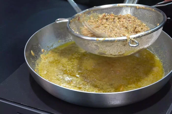 Strain the minced shrimp heads.
