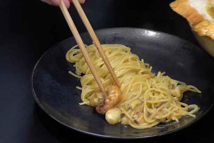 Plate the gambas ingredients on top of the pasta.