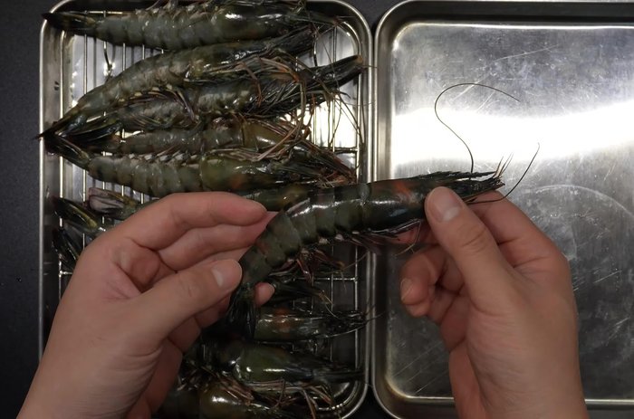 Start by cutting off the shrimp's head and peeling it.