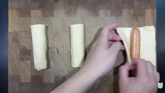 Put sausages one by one on the pastry dough and roll it up. Then, cut the dough with scissors and spread it out alternately left and right.