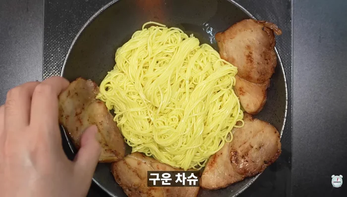 Add grilled char siu, bean sprouts, and kelp to the ramen bowl.