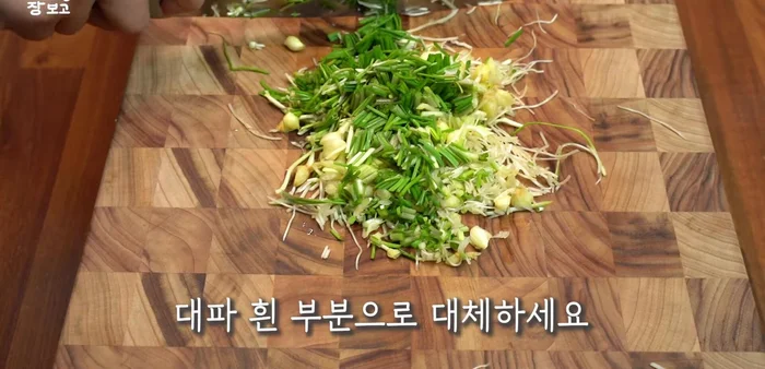 While the rice cooks, prepare the seasoning sauce: Finely chop chives (or substitute with green onion), minced garlic, chili peppers, and mix with red pepper powder, plum extract, soy sauce, sesame oil, and toasted sesame seeds.