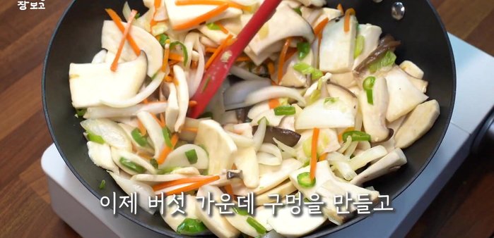 Make a well in the center of the mushrooms, increase the heat to high, and pour in the seasoning sauce.