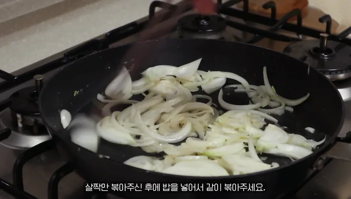 Add rice to the pan and fry it together with the onions.