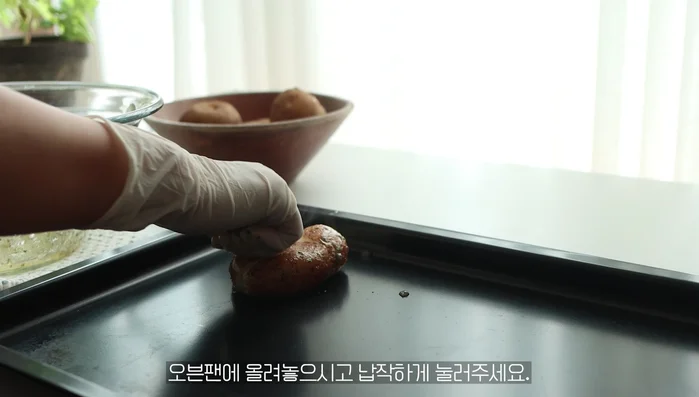 Place potatoes on an oven plate and press them flat.
