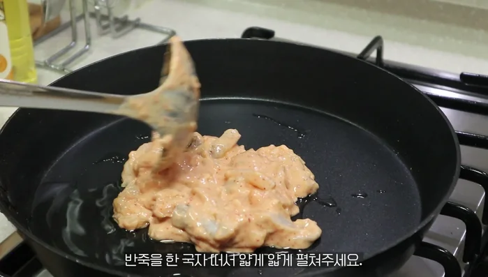 Spoon the dough onto the pan and spread it thinly.