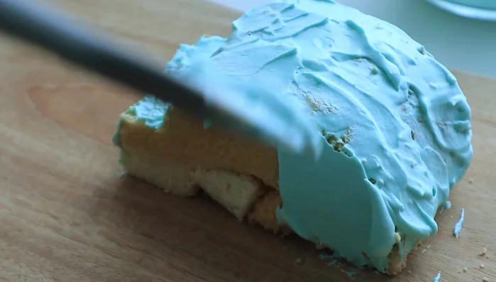 Cut the second castella slice in half and arrange the pieces to create the desired shape.