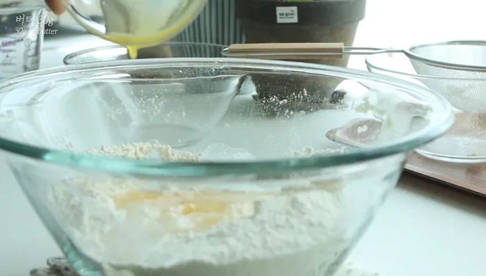 Add warm water, medium-sized butter, and mix. Add the egg and mix.