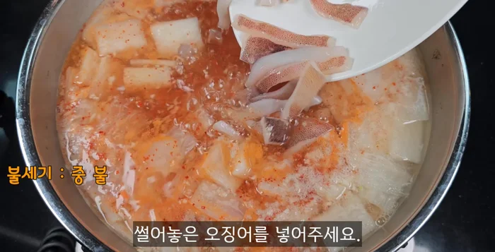 Add a spoonful of red pepper powder. Add the cut squid and boil for 2 minutes.