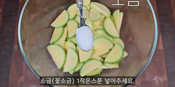 Put sliced zucchini in a bowl, add salt, mix well, and marinate for 20 minutes. This prevents crumbling during stir-frying.