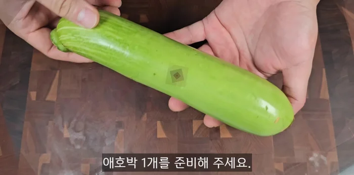 Prepare one zucchini. Cut off the tops, cut it in half, and slice into 0.3cm thick half-moon shapes.