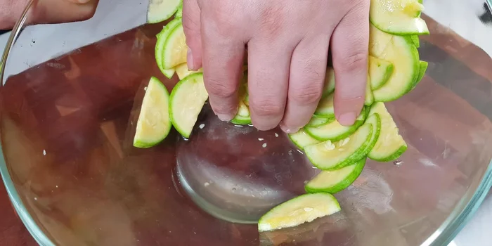 After 20 minutes, the zucchini should be well-pickled. Add 2 tablespoons of cooking oil to a pan over medium heat.