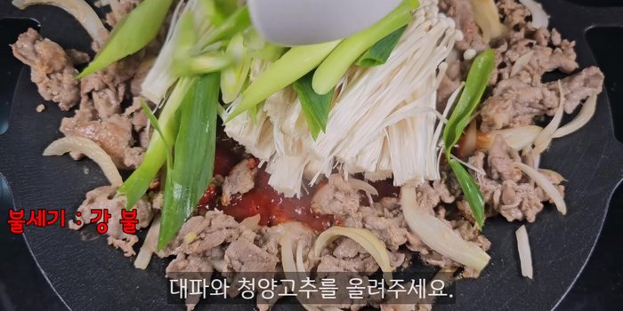 Add the enoki mushrooms, green onions, and Cheongyang peppers. Stir-fry until well mixed and heated through.