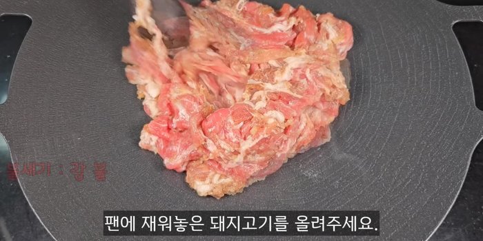 Heat the pan and add the marinated pork. Stir-fry until the surface is cooked and slightly browned.