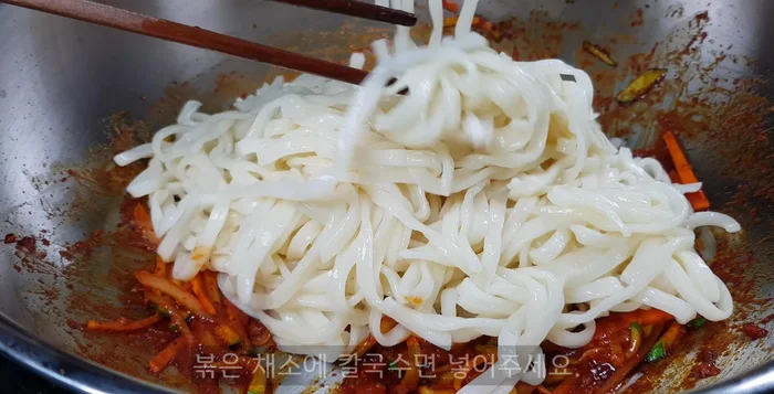 Add the cooked noodles to the wok with the stir-fried vegetables. Add the reserved noodle water.