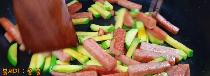 Lightly mix the zucchini and Spam. Stir-fry for about 1 minute.