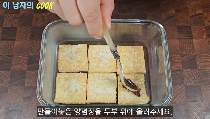Layer the fried tofu in the container. Drizzle about half a teaspoon of the seasoning sauce over each layer of tofu. Repeat the layers until all the tofu and sauce are used.
