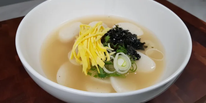 Serve the tteokguk, garnishing with the prepared egg, green onions, and seaweed.