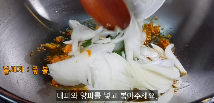 Stir-fry vegetables: Add the chopped green onions and thinly sliced onions, stir-fry until fragrant (about 30 seconds).
