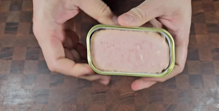 Remove the yellow safety cap from the Spam can and open it. Cut the Spam lengthwise into four pieces, then cut each piece into four more, creating radish-sized pieces.