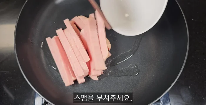 Heat a pan with a spoonful of cooking oil. Add the Spam slices and cook on high heat, turning frequently until all four sides are dark brown.