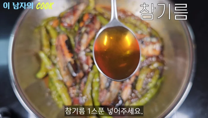 When the sauce thickens, add a spoonful of sesame oil. Turn off the heat, sprinkle with sesame seeds, and mix well.
