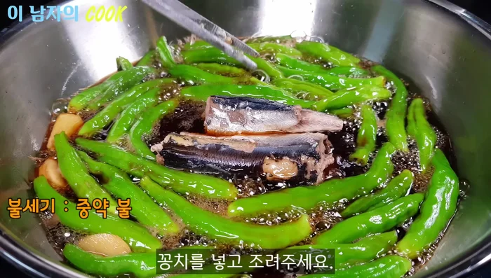 Add the prepared mackerel to the pan. Continue to simmer over medium-low heat, uncovered, for about 10 minutes, carefully turning the mackerel to prevent it from breaking apart.
