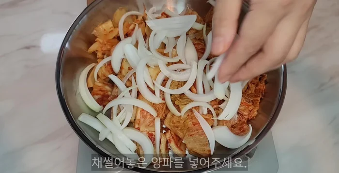 In a pot, add kimchi, onion, 4 tbsp sesame oil (or substitute), and anchovies for broth (remove intestines). Stir-fry until kimchi softens and onions are mushy.
