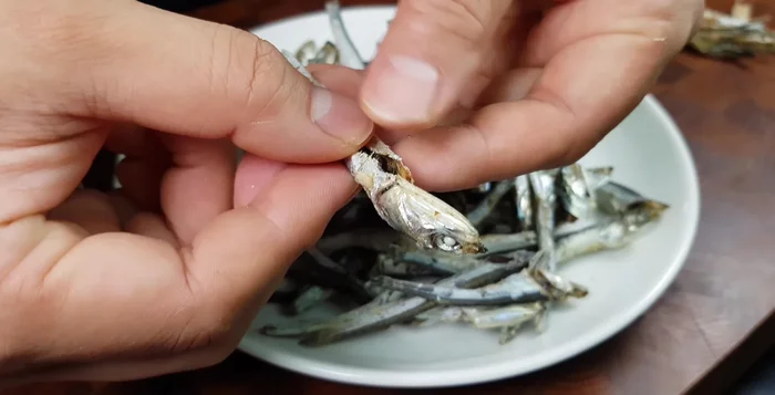 Prepare Anchovy Garnish: Cut anchovies in half, remove heads and bones. Slice garlic and chili peppers.