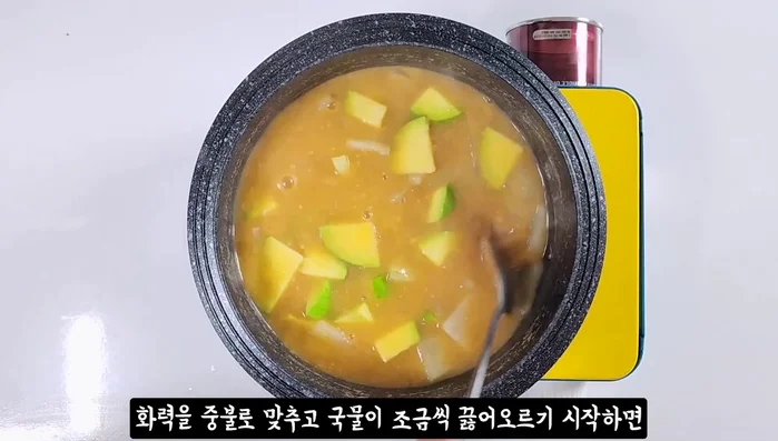 When the broth starts to simmer, add zucchini and onion.