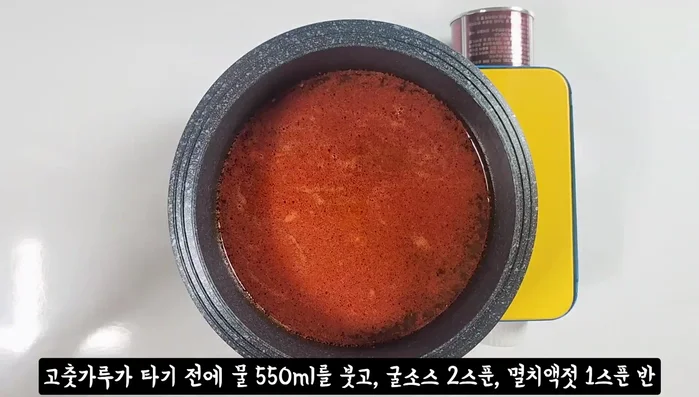 Before the chili powder burns, pour in 550ml of water. Add 2 tablespoons of fire sauce, 1.5 tablespoons of anchovy sauce, and 1 tablespoon of beef dashi.